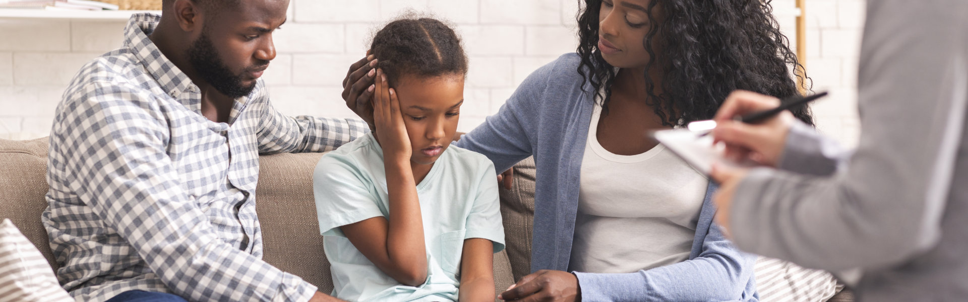 A family sitting on a couch while listening to the advice of a psychiatrist