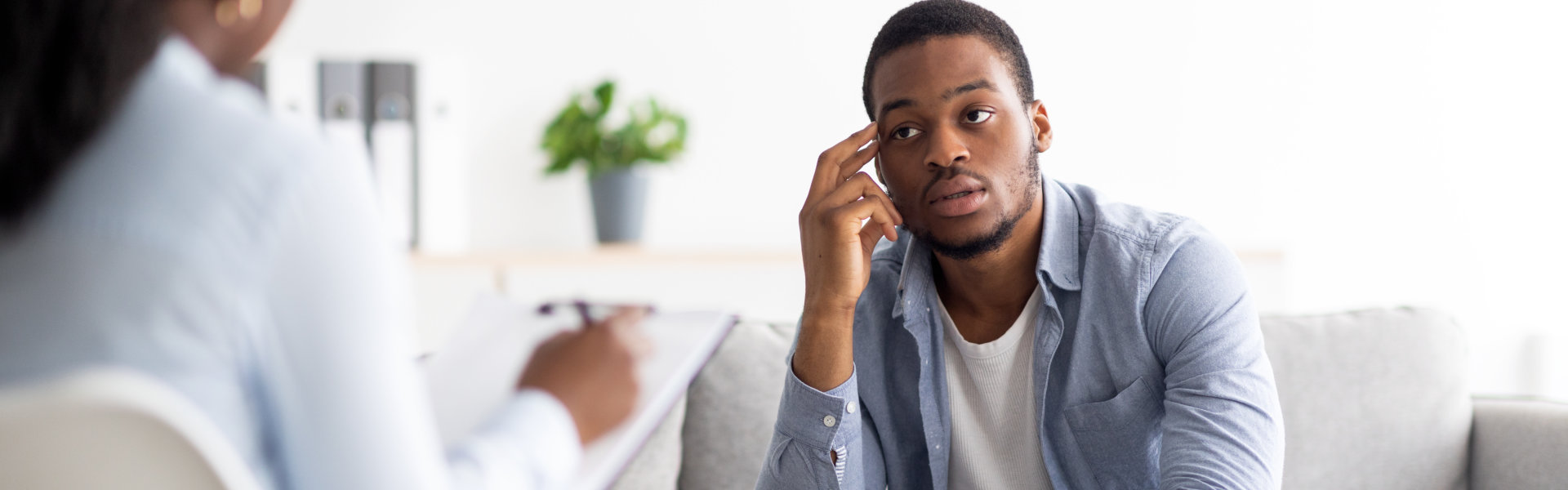 A man sitting on a couch while listening some advice to his psychiatrist