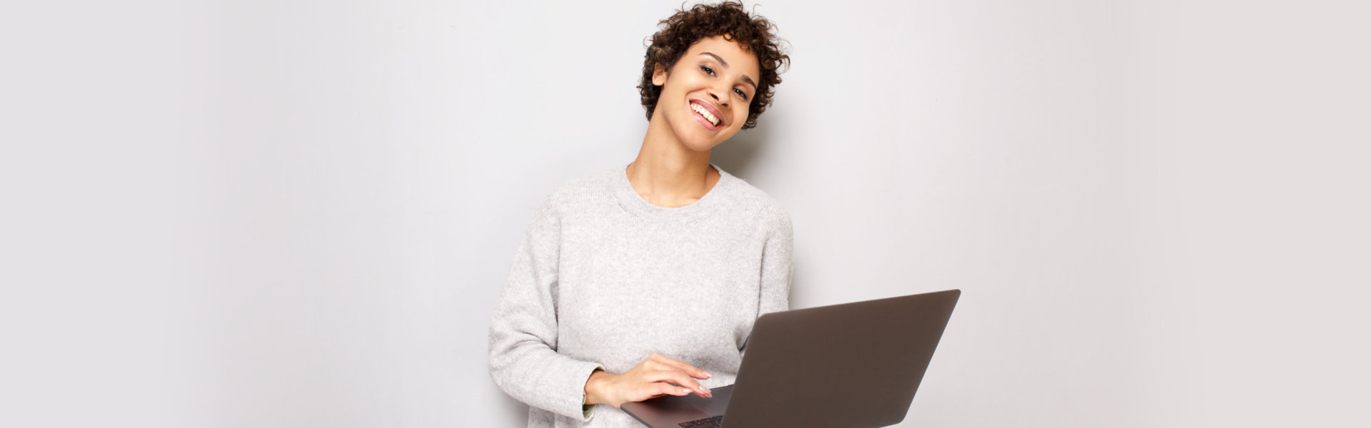 smiling woman holding laptop